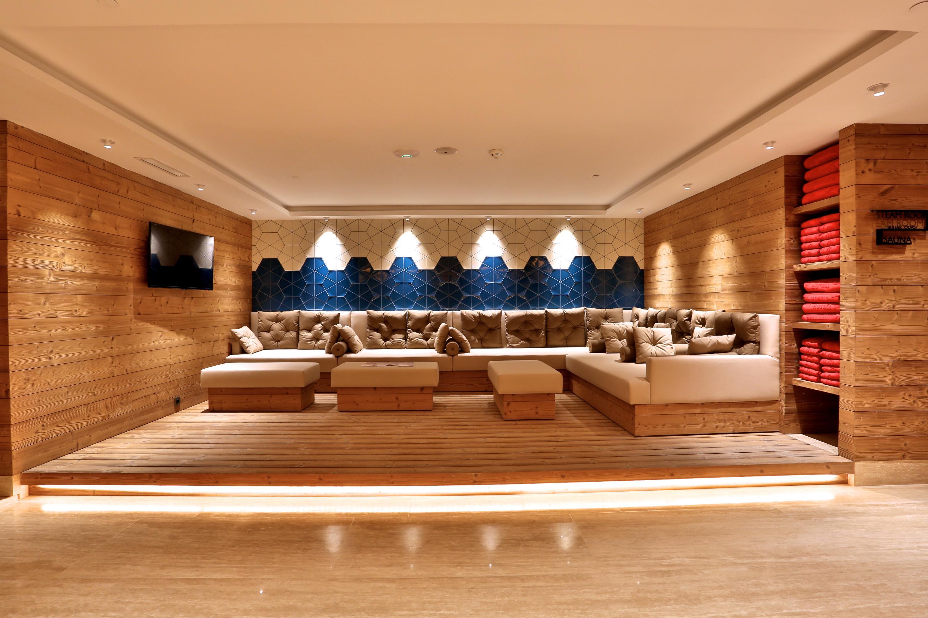 Dosso Dossi Hotels & Spa Downtown Istanbul Luaran gambar The photo shows a cozy and modern lounge or relaxation area. It features wooden walls and a light-colored wooden floor, creating a warm atmosphere. The seating consists of plush couches with decorative cushions in neutral tones, arranged around a low