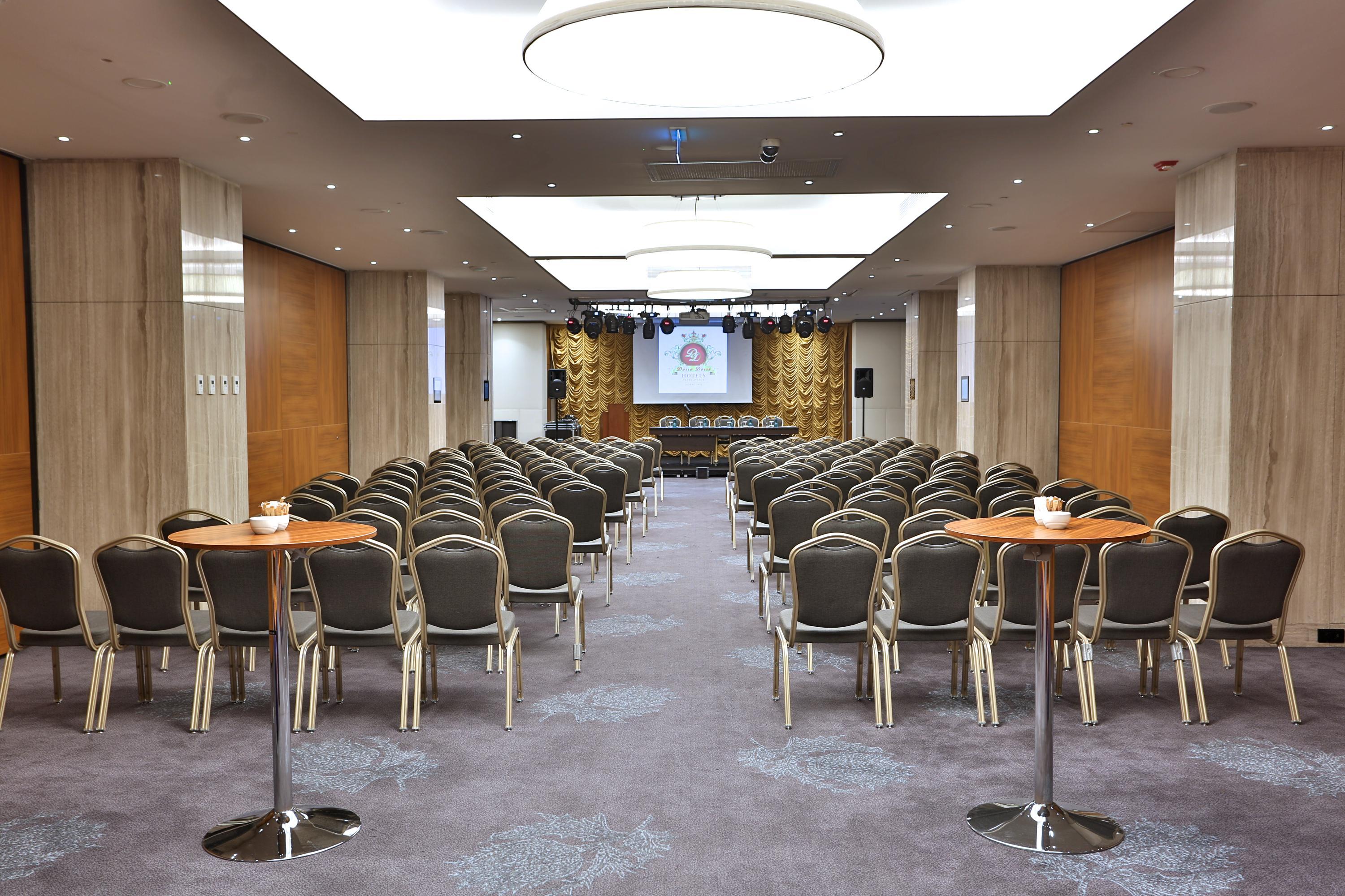 Dosso Dossi Hotels & Spa Downtown Istanbul Luaran gambar The photo shows a spacious meeting or conference room. There are many rows of chairs arranged in a theater-style setup, indicating that it's likely meant for presentations or lectures. In the front of the room, there is a stage or platform area with 