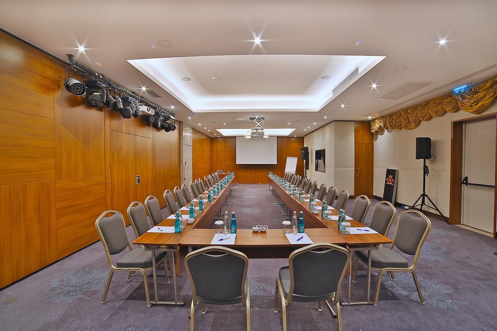 Dosso Dossi Hotels & Spa Downtown Istanbul Luaran gambar The photo shows a conference room set up for a meeting. There are two long tables arranged in a rectangular shape, with several chairs placed around them. Each chair has a small bottle of water and a notepad on the table in front of it. The room feat